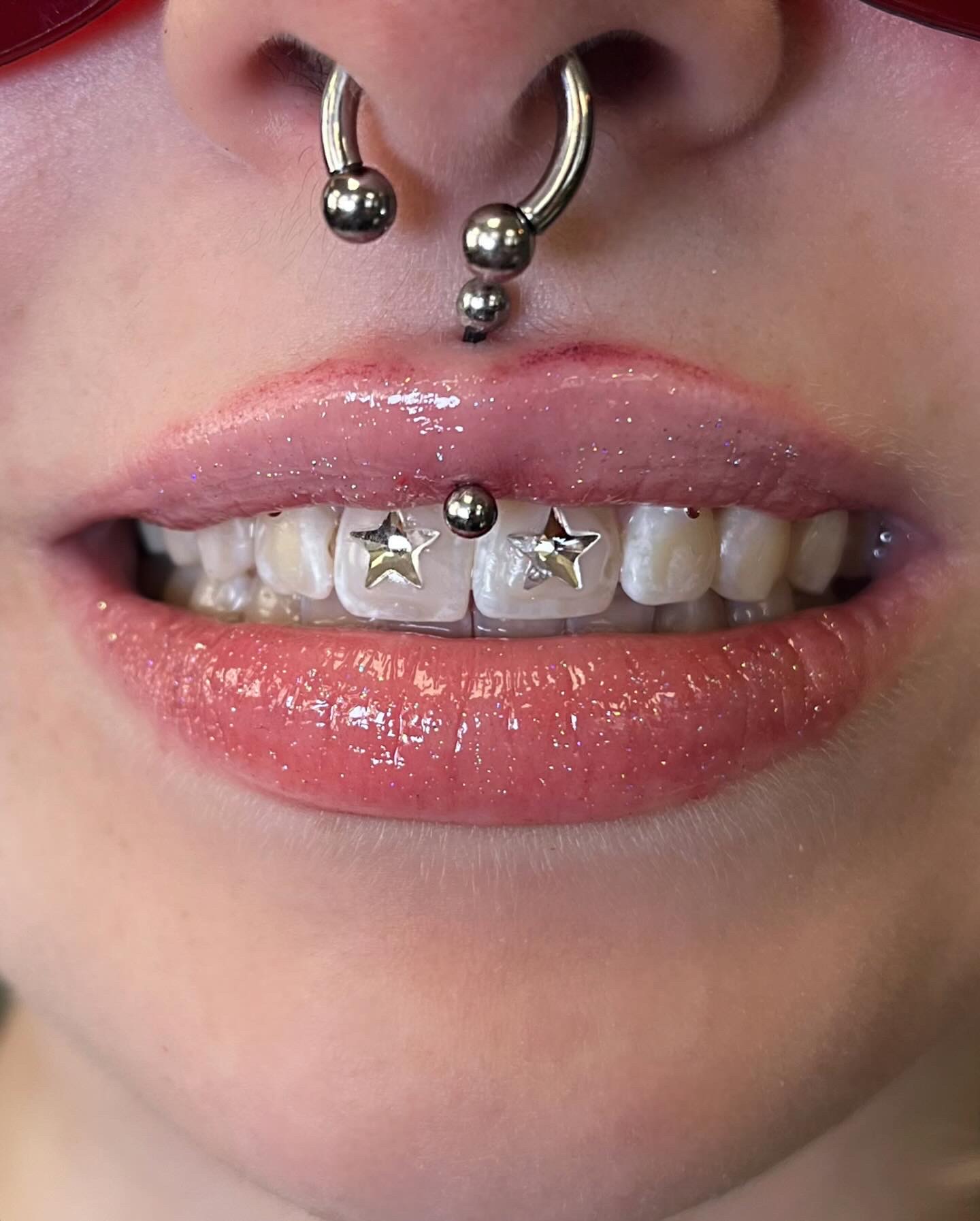 Silver star tooth charms on the front teeth
